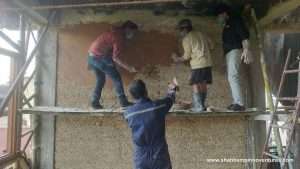 Participants and local mason learning lime plaster application