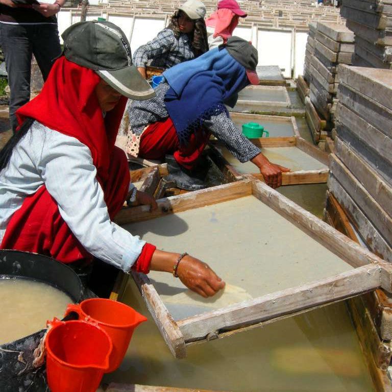 Artisan crafting hemp paper in Nepal with traditional tools and techniques.